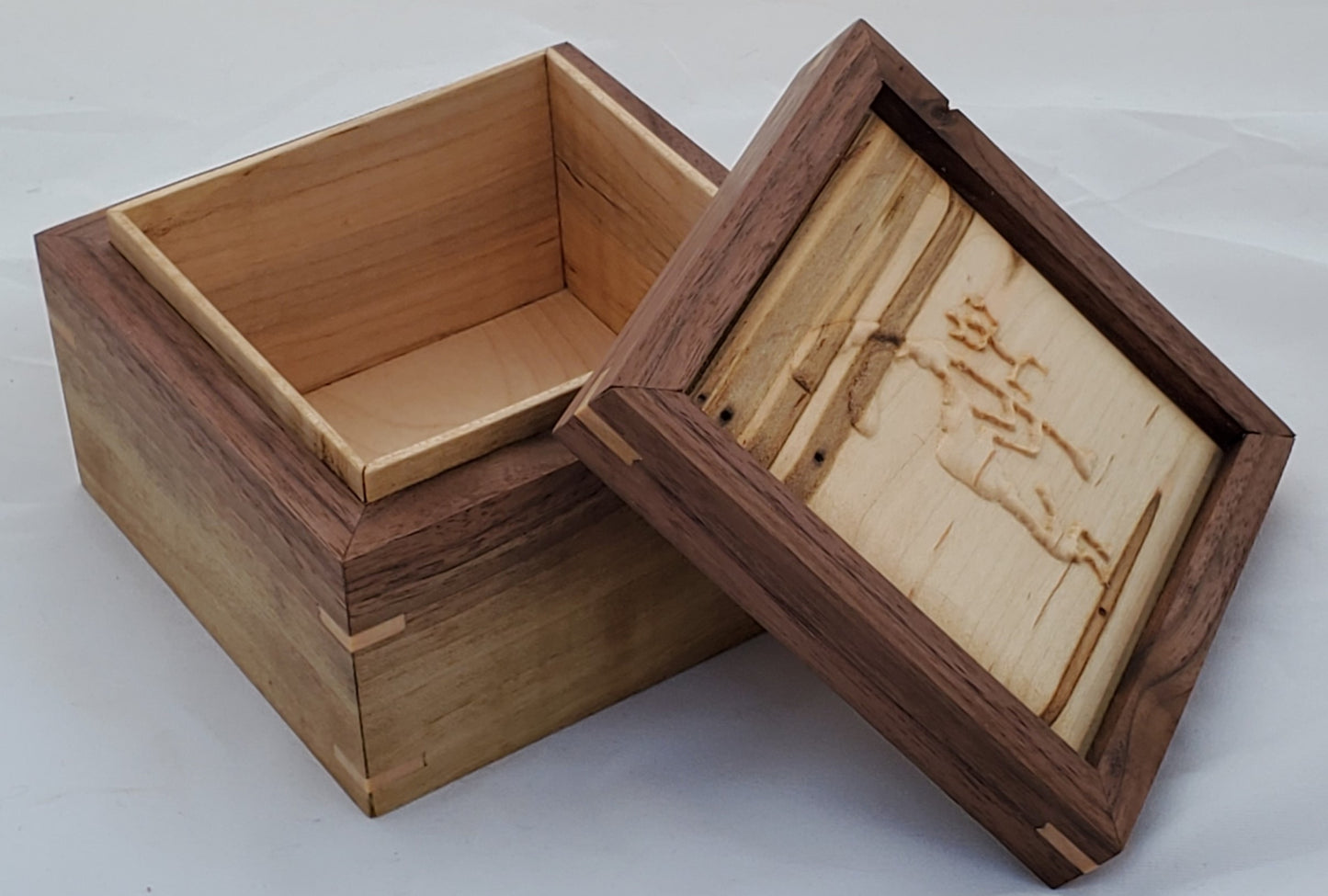 Walnut keepsake box or pet urn with a carved Kokopelli top cover