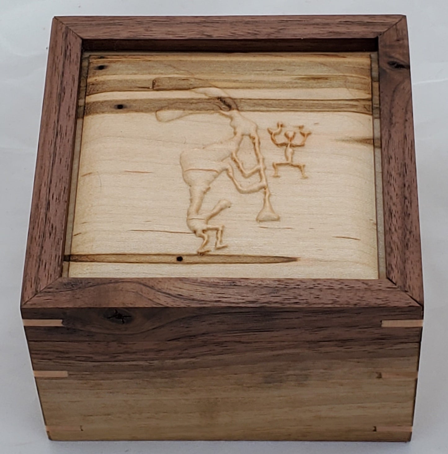 Walnut keepsake box or pet urn with a carved Kokopelli top cover